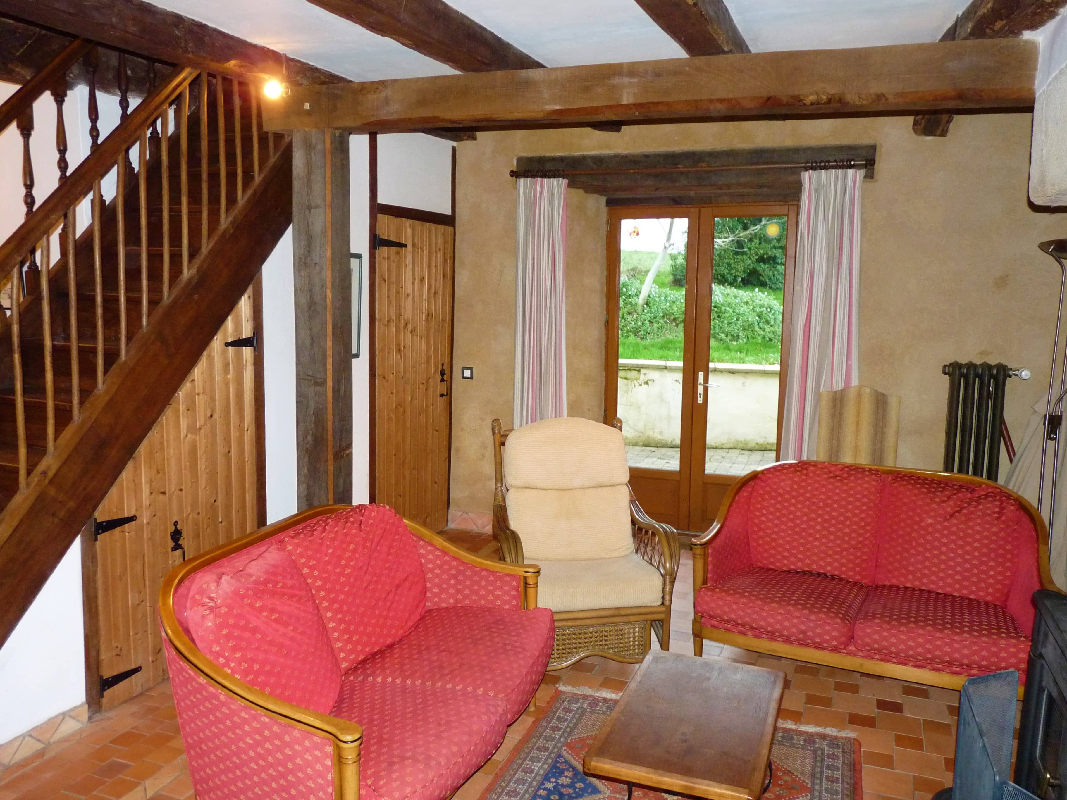 Comfortable living room of La Julerie cottage in Brittany, France, with a view of the surrounding nature and equipped with modern furniture. Ideal for relaxing after a day of sightseeing in Brittany.